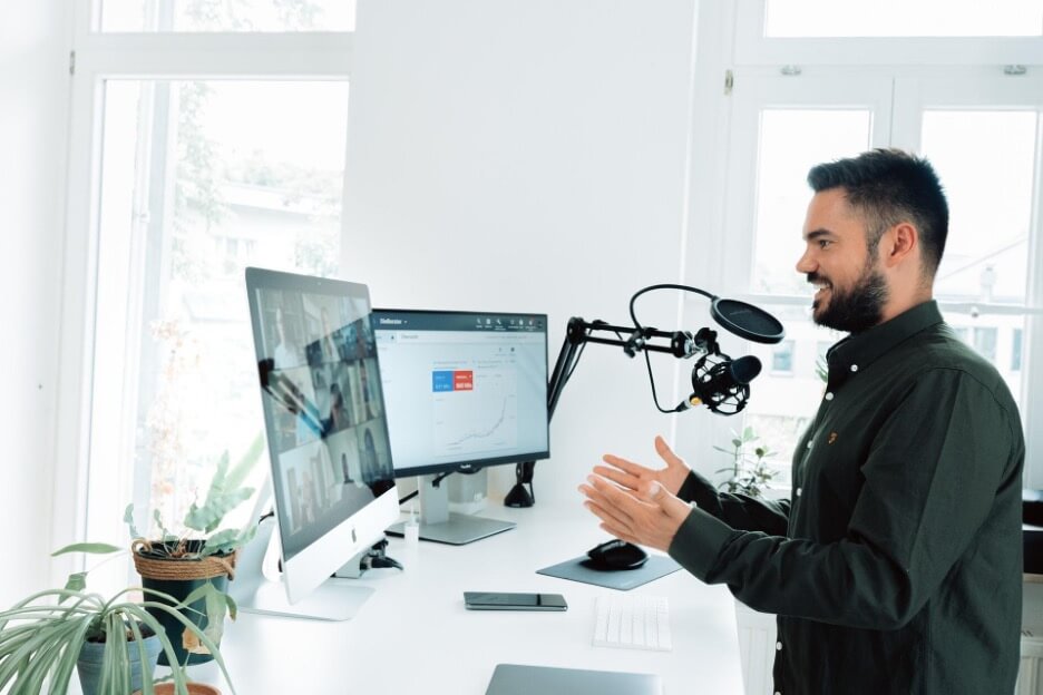 Man with a black shirt in the middle of a livestream session explaining his ideas to his viewers.