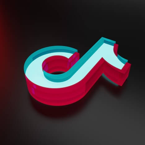 TikTok’s 3D logo (resembling a multi-color musical note) floats above a black satin-finished surface.