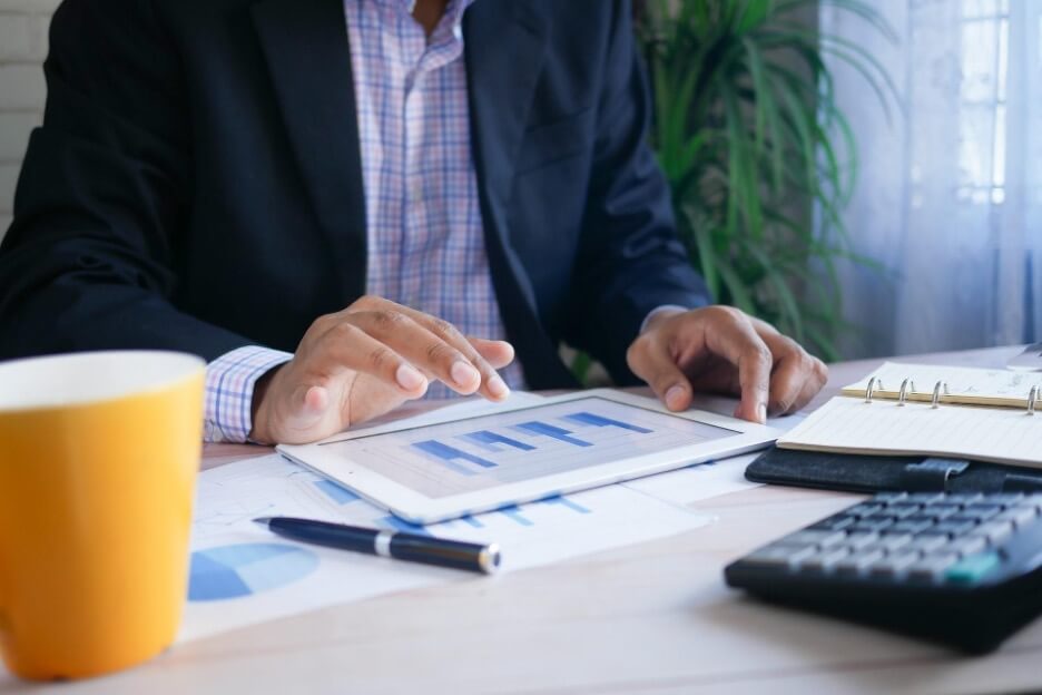 A social media marketer gets a report ready on a tablet for a client.