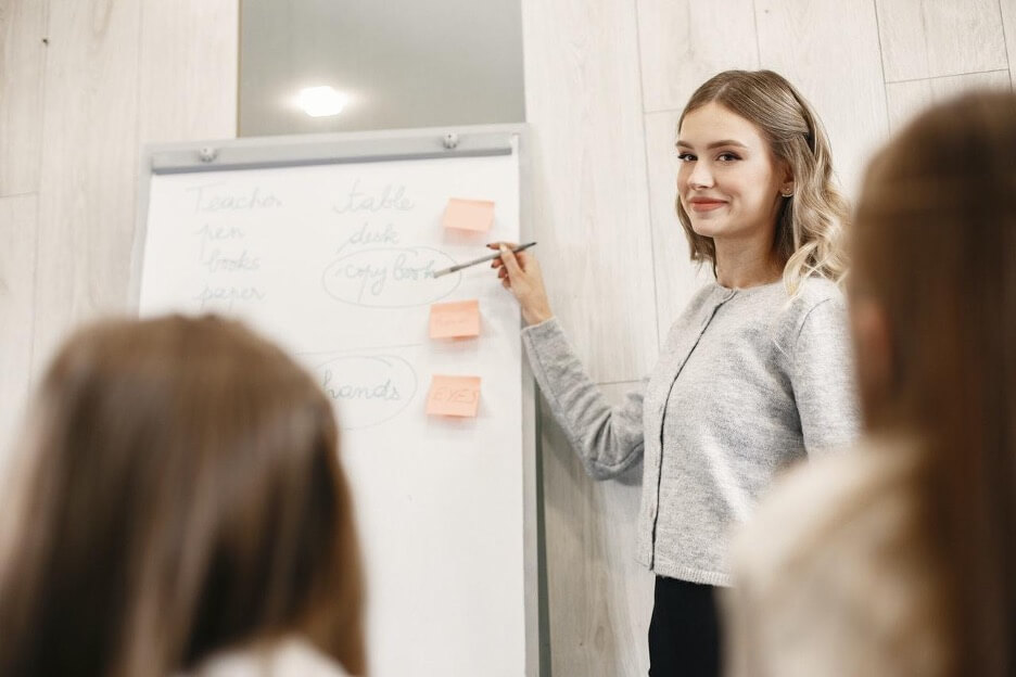 A digital marketing employee explains a new strategy for a client to her co-workers.