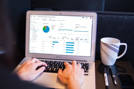 A person looks at a Google analytics page of their website on their MacBook.