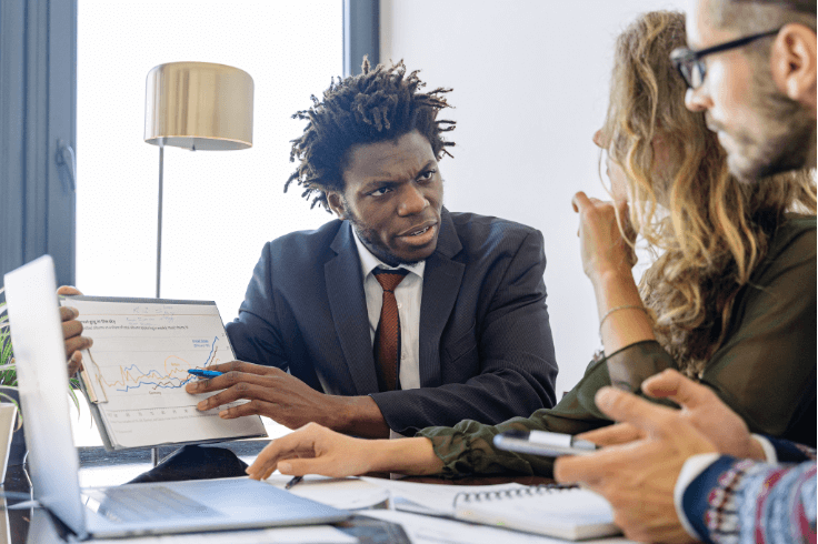 A marketing strategist reviews the analytics with two clients.