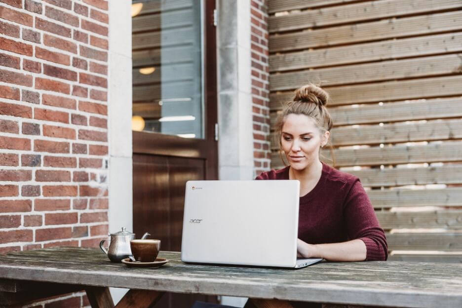 A social media manager from a marketing company responds to messages on her Acer laptop 