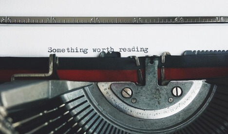 This is an image of a typewriter with the words “Something worth reading” typed on white paper.