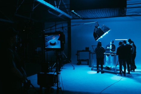 A group of video marketing employees film a video in the studio for a new client.