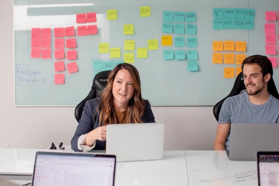 A woman explains her social media strategy to her coworkers in a meeting.