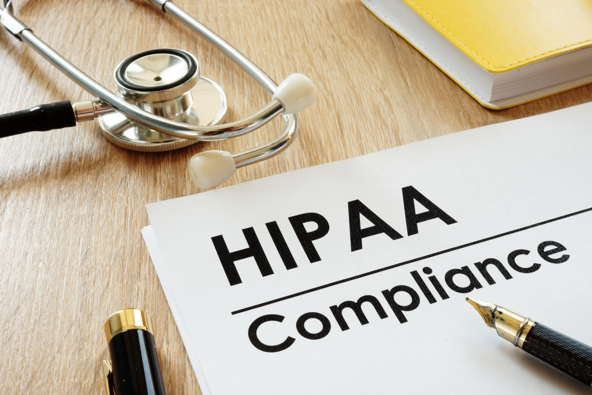 HIPAA Compliance application and stethoscope on a desk.